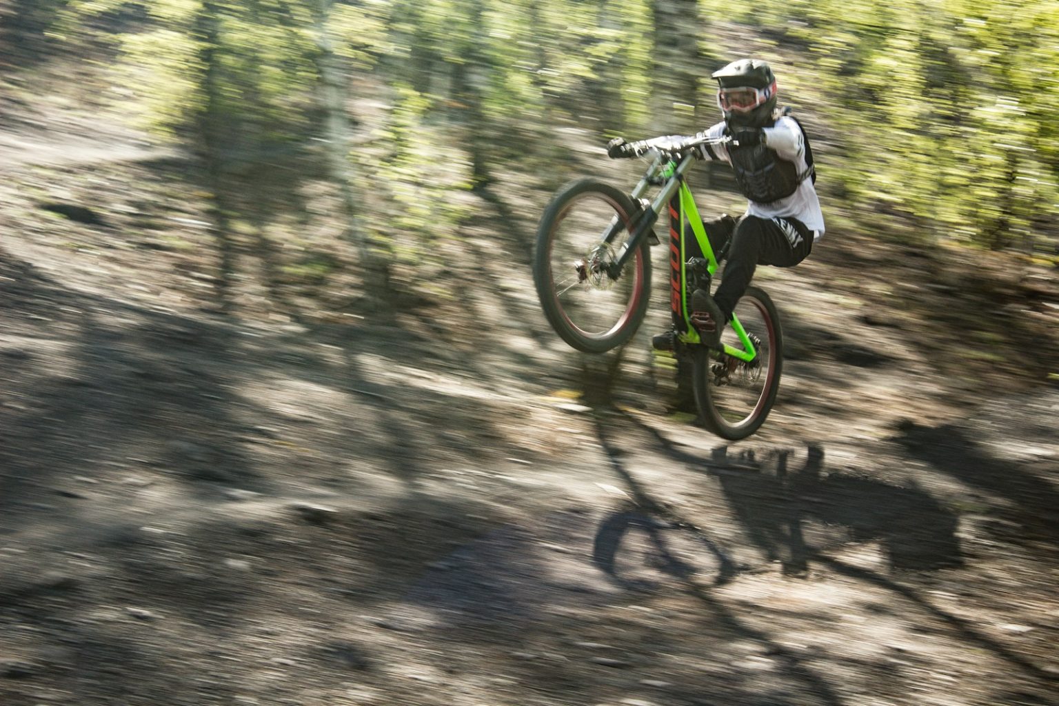 a person riding a bike on a trail in the woods