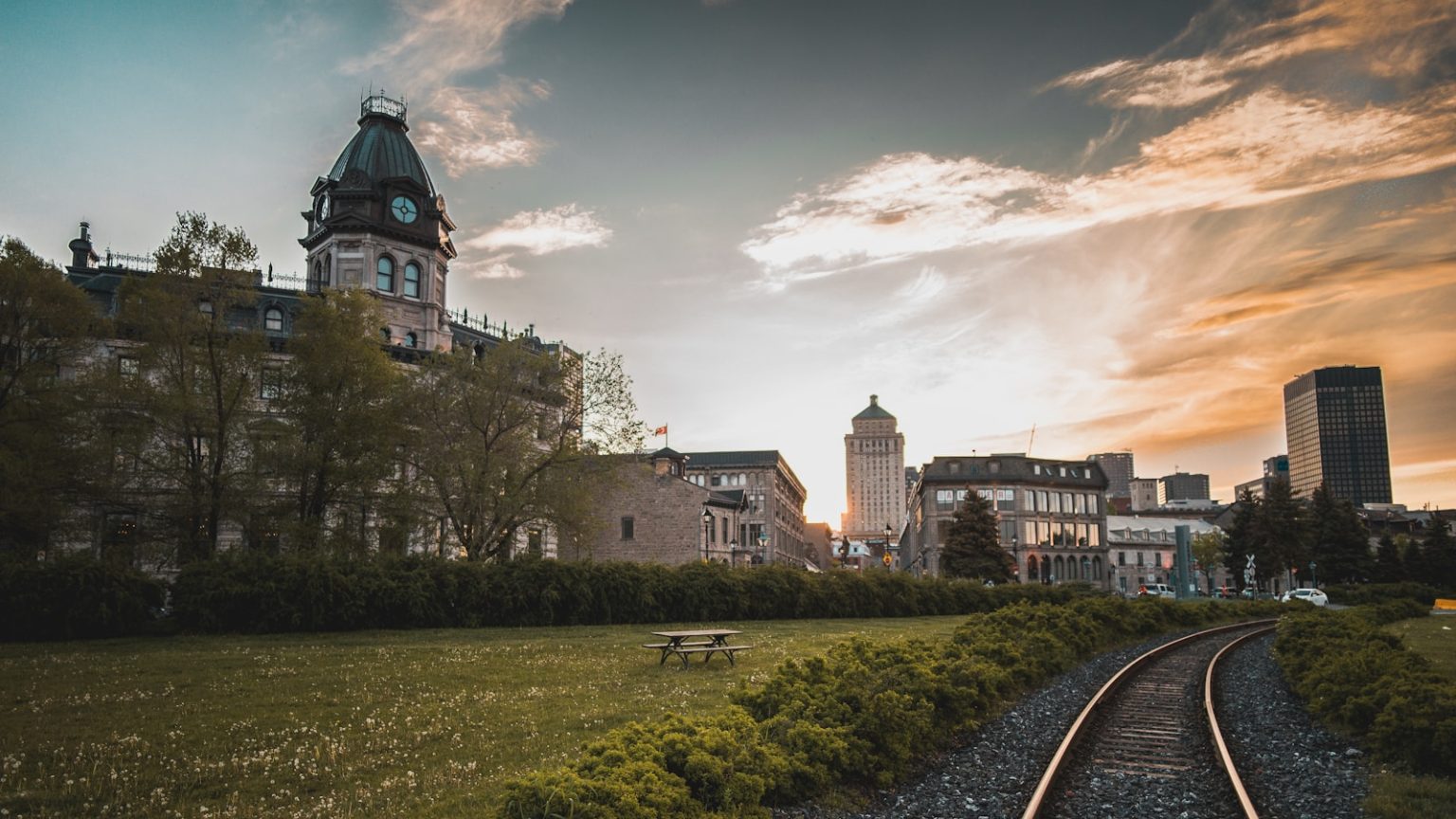 train rail near concrete houses during daytime